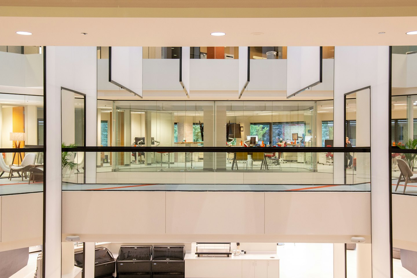 Atrio de oficina moderno con espacios de paredes de cristal y mobiliario contemporáneo.