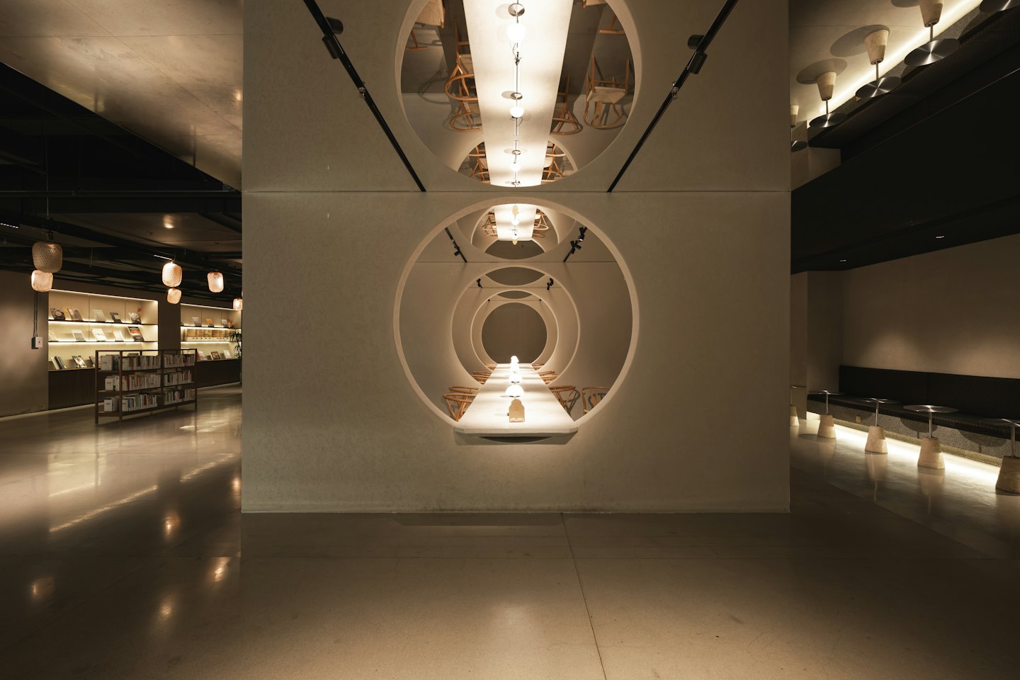 Espacio comercial moderno con recortes circulares en la pared y decoración minimalista.